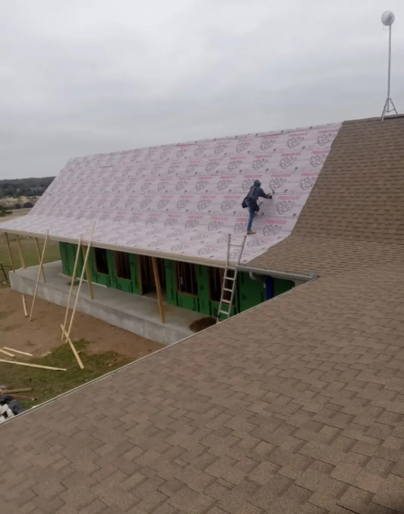 Worker preparing underlayment for a metal roof installation in Pollock Pines